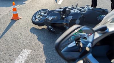 Image of moped on its side on road following a collision