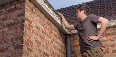 man inspecting the roof of his home